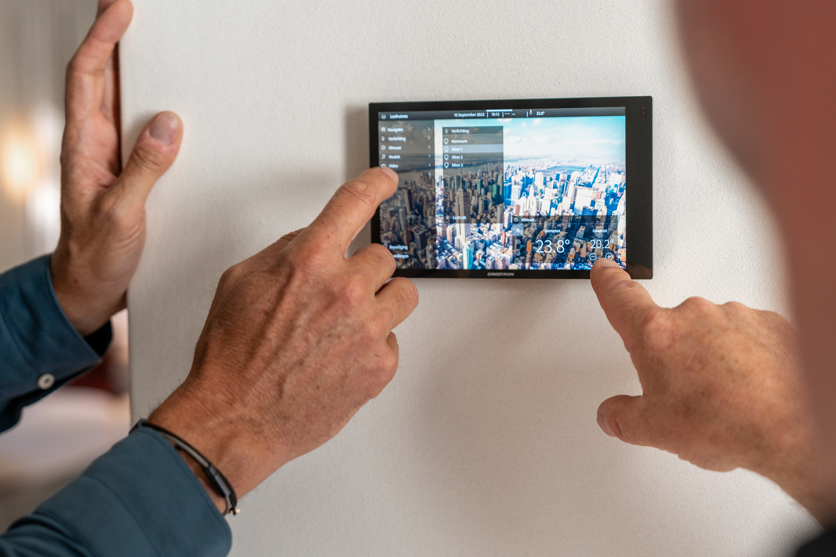 A man adjusts the indoor climate of his home with one simple touch on a screen thanks to a modern home automation system.