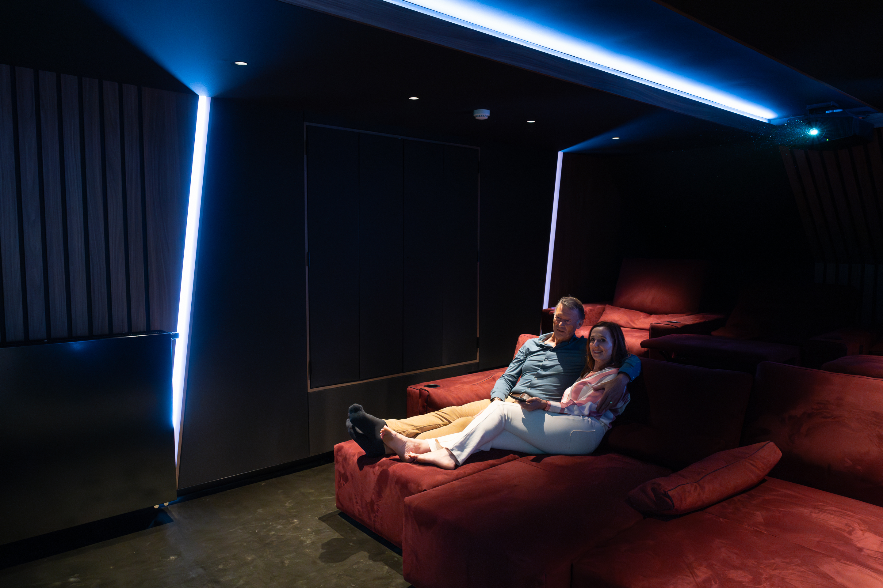 A man and a woman experience the comfort of a home cinema.