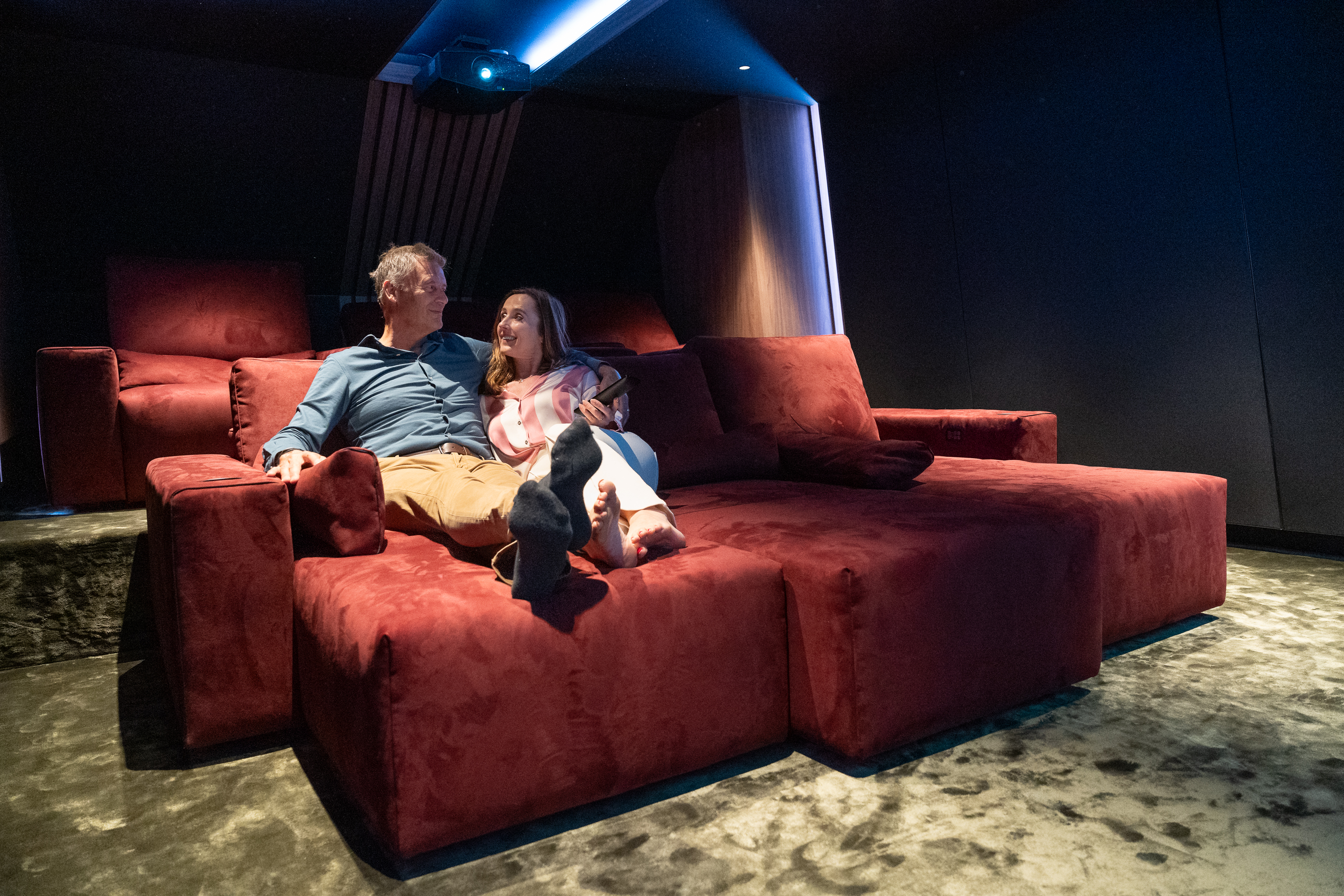 A man and a woman have a demo to experience the atmosphere of a home cinema.